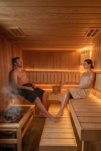 A couple relaxing inside the modern wooden sauna at Noblethorpe Hall’s luxury wellness spa and private estate in Silkstone, Barnsley.